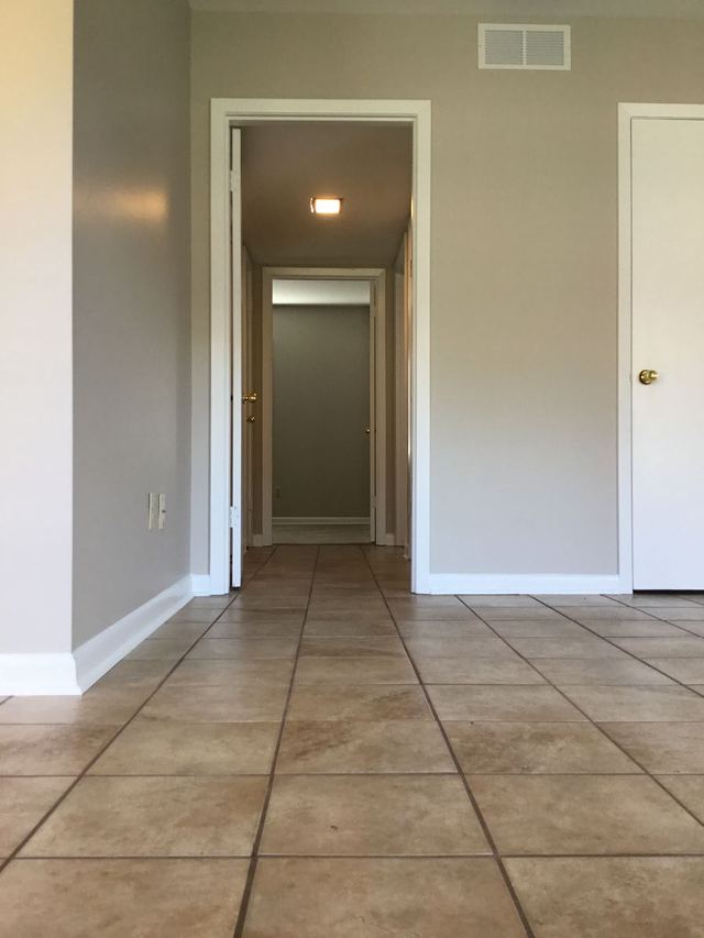 Tiled hallway in Unit 103 leading past interior doors