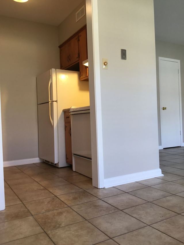 Kitchen in Unit 103 with a stainless steel sink, speckled stone-look countertops, and wood cabinets