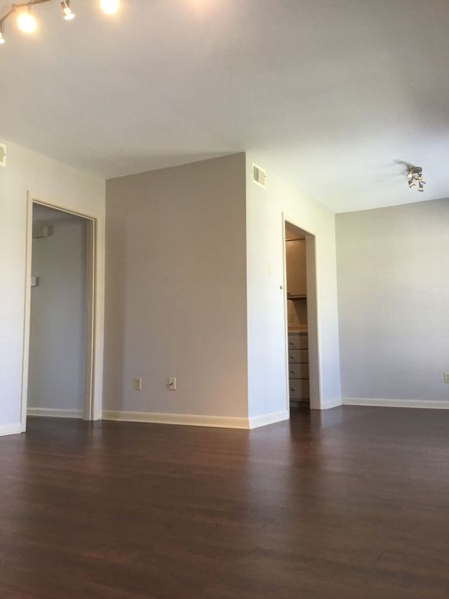 Living room in Unit 204 looking toward doorways and a closet with built-in drawers