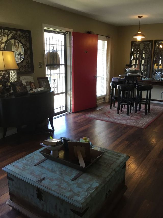 Decorated living area in Unit 207 looking toward the red front door — furniture not included