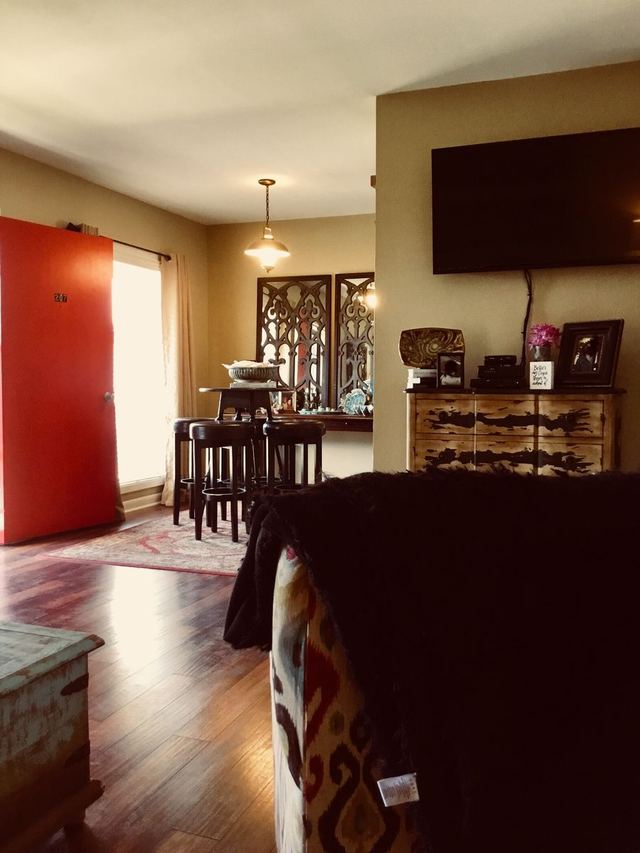 Decorated living and dining area in Unit 207 toward the entry door — furniture not included