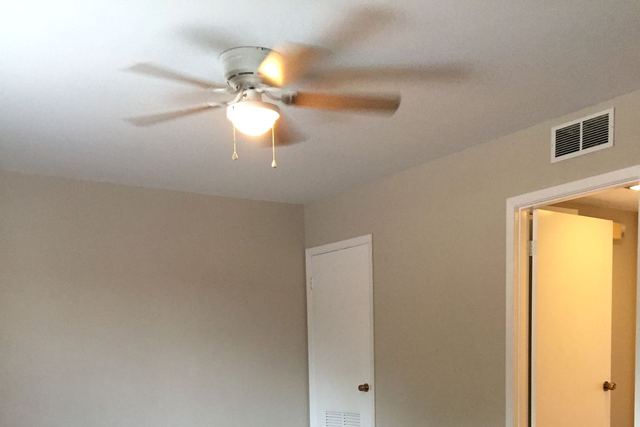 Upgraded unit living area with Agreeable Gray walls, dark wood-look flooring, and a ceiling fan
